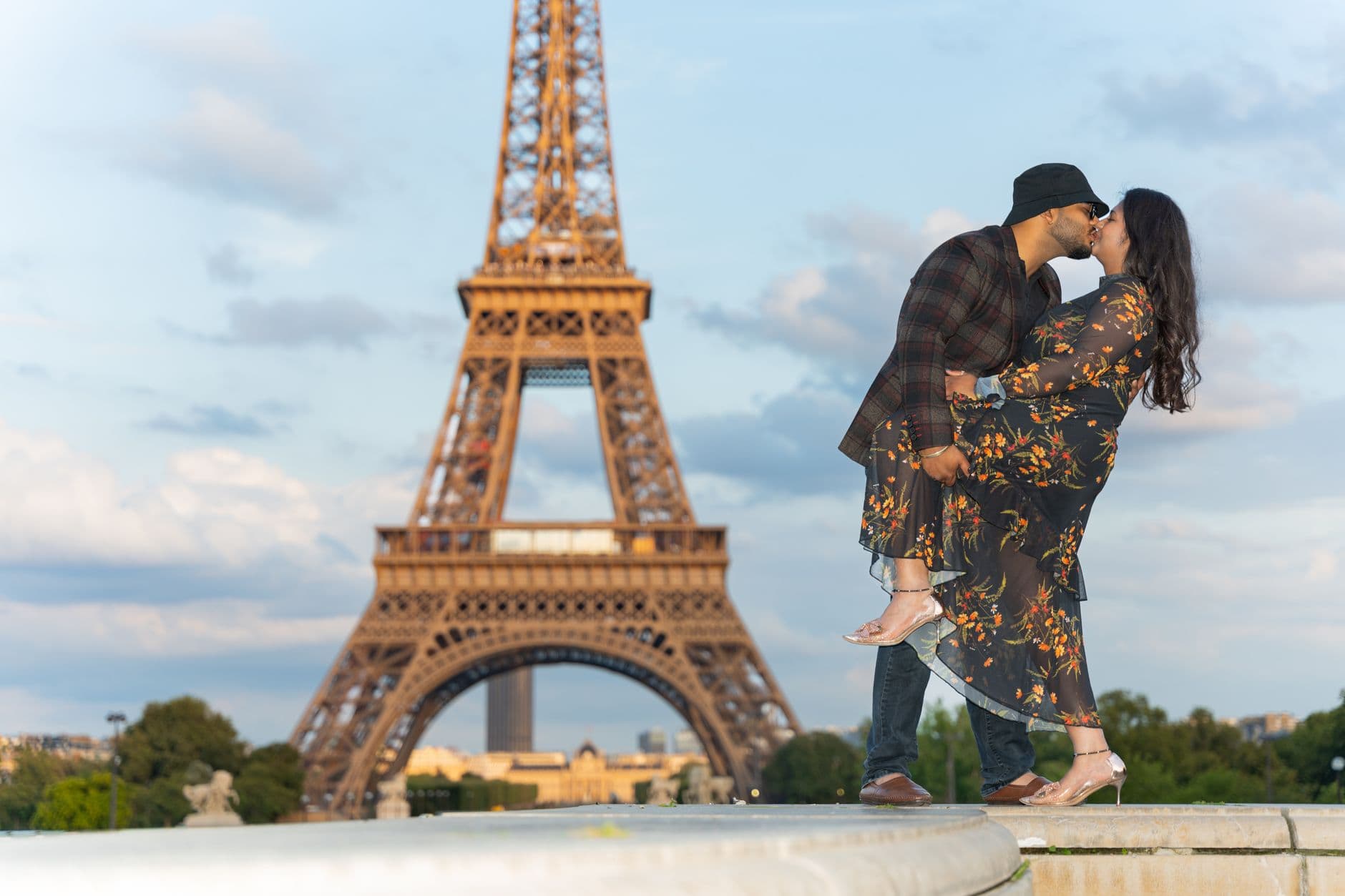 A couple shares a romantic kiss near the Eiffel Tower in Paris, France.
